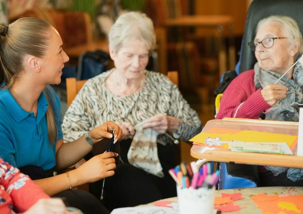 3 Frauen, zwei Stricken und eine jüngere hilft